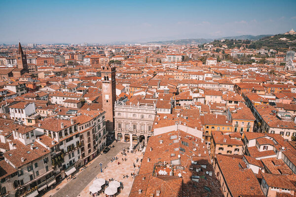 Verona, Italy. April 10, 2018. Aerial view of the old town of Verona with amazing narrow streets, orange rooftops and people in the center of the city.