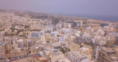Geleneksel Malta Luzzu balıkçı tekneleri ve güzel manzaralı St Julian, Sliema ve Valetta şehirler yukarıdan Spinola Bay üzerinde havadan görünümü. 