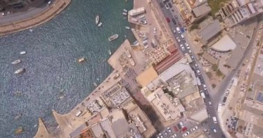 Geleneksel Malta Luzzu balıkçı tekneleri ve güzel manzaralı St Julian, Sliema ve Valetta şehirler yukarıdan Spinola Bay üzerinde havadan görünümü. 