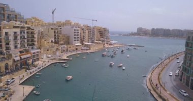 Geleneksel Malta Luzzu balıkçı tekneleri ve güzel manzaralı St Julian, Sliema ve Valetta şehirler yukarıdan Spinola Bay üzerinde havadan görünümü. 