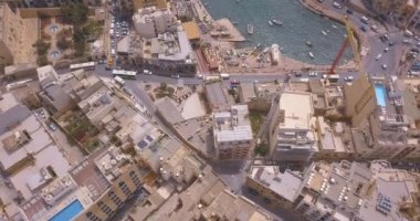 Geleneksel Malta Luzzu balıkçı tekneleri ve güzel manzaralı St Julian, Sliema ve Valetta şehirler yukarıdan Spinola Bay üzerinde havadan görünümü. 