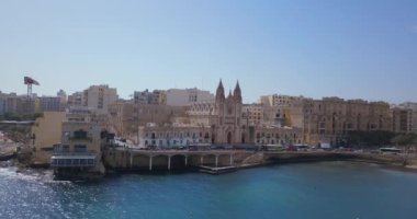 Geleneksel Malta Luzzu balıkçı tekneleri ve güzel manzaralı St Julian, Sliema ve Valetta şehirler yukarıdan Spinola Bay üzerinde havadan görünümü.