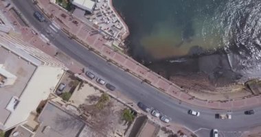 Geleneksel Malta Luzzu balıkçı tekneleri ve güzel manzaralı St Julian, Sliema ve Valetta şehirler yukarıdan Spinola Bay üzerinde havadan görünümü.