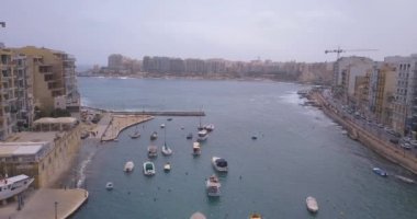 Geleneksel Malta Luzzu balıkçı tekneleri ve güzel manzaralı St Julian, Sliema ve Valetta şehirler yukarıdan Spinola Bay üzerinde havadan görünümü. 