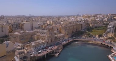 Geleneksel Malta Luzzu balıkçı tekneleri ve güzel manzaralı St Julian, Sliema ve Valetta şehirler yukarıdan Spinola Bay üzerinde havadan görünümü.