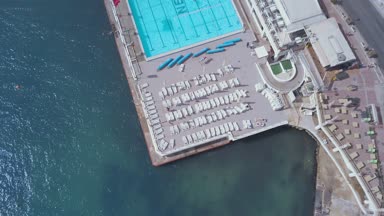 Geleneksel Malta Luzzu balıkçı tekneleri ve güzel manzaralı St Julian, Sliema ve Valetta şehirler yukarıdan Spinola Bay üzerinde havadan görünümü.