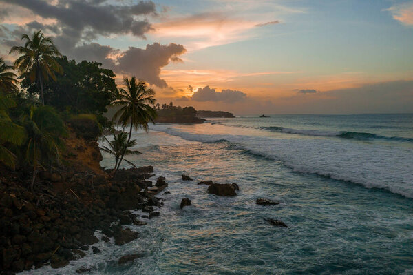 Beautiful tropical beach near the shore with huge waves and tall palm trees. Holidays heaven background.
