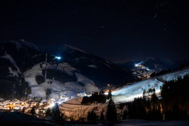 Alpler 'de güzel bir gece. Gökyüzü yıldızlarla dolu dağların arasında küçük bir kayak köyü..