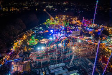London, UK. December 2, 2019. London Wonderland. Night view of people walking in the Hyde Park's winter Wonder Land between different rides and attractions. Beautiful Christmas spirit in London.