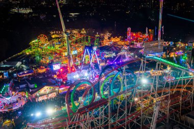 London, UK. December 2, 2019. London Wonderland. Night view of people walking in the Hyde Park's winter Wonder Land between different rides and attractions. Beautiful Christmas spirit in London.