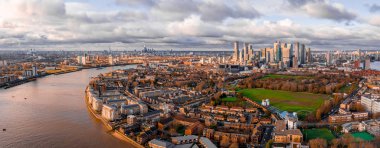 Londra, İngiltere - Merkez Londra 'nın önde gelen finans bölgeleri Bank ve Canary Wharf' ın gökdelenleri bulutlu gökyüzü sırasında altın saat günbatımında gökdelenlerle gökyüzü manzarası. 