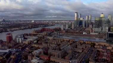 Aerial Panoramic skyline view of Bank and Canary Wharf, central London's leading financial districts with famous skyscrapers at golden hour sunset during cloudy skies. London, England