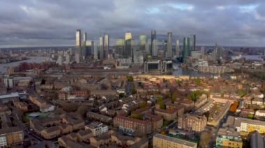 Aerial Panoramic skyline view of Bank and Canary Wharf, central London's leading financial districts with famous skyscrapers at golden hour sunset during cloudy skies. London, England