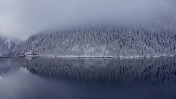 在寒冷 阳光明媚 蓝天白云的日子里 瑞士阿尔卑斯山雪峰映衬下美丽的白色冬季仙境全景映照在晶莹清澈的山湖上 — 图库视频影像