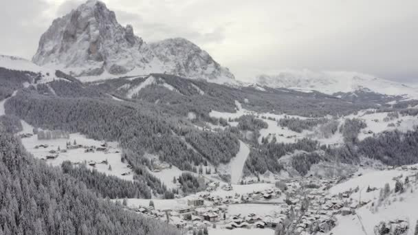 Sjezdovka na alpském lyžařském středisku Val Gardena v Itálii. Mohutné Dolomitské hory a les pokrytý sněhem.