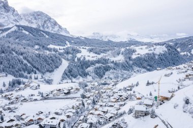 Slope on the Alpine skiing resort Val Gardena in Italy. Mighty mountains and forest covered in snow.