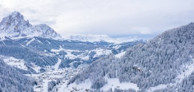 Slope on the Alpine skiing resort Val Gardena in Italy. Mighty mountains and forest covered in snow.