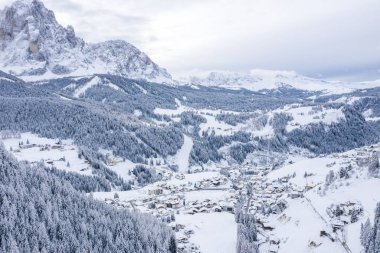 Slope on the Alpine skiing resort Val Gardena in Italy. Mighty mountains and forest covered in snow.