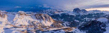Beautiful mountain sunset in Italian Alps over Dolomite cliffs. Aerial panoramic view near Val Garden Ski resort.