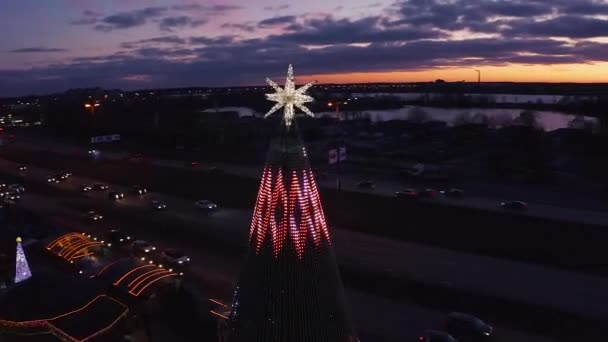 ラトビアのリガに位置するヨーロッパで最も美しいクリスマスツリーは リドのレストラン施設で クリスマスツリーの美しい夜景とクリスマスアイススケートを祝う人々 — ストック動画