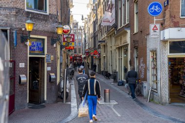 Amsterdam, Hollanda. 10 Haziran 2019. Amsterdam şehrinin ufuk çizgisi batımı Amsterdam, Hollanda. Amsterdam 'ın işlek sokaklarında yürüyen insanlar.