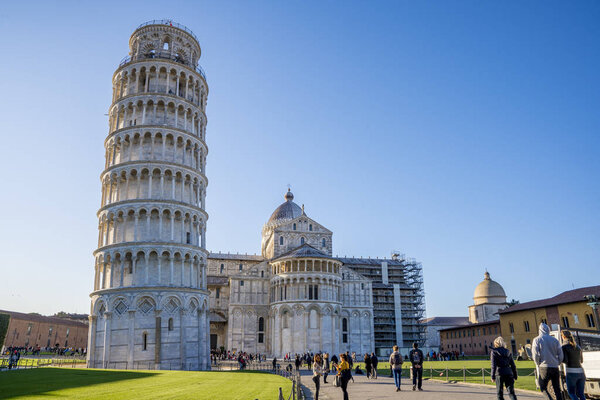 Pisa, Italy. May 10, 2019. View of the Pisa tower in Pisa, Italy. People walking around the tower taking photos. Pisa tower during clear sunny day.