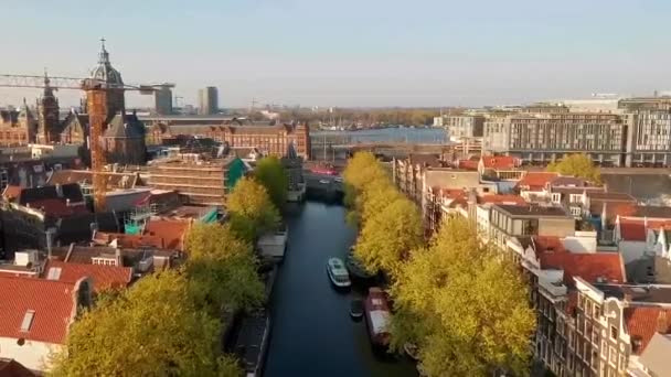 アムステルダム オランダ ヴェスターケルク教会と橋やボートのトラフィックを持つ狭い運河のドローンビュー — ストック動画