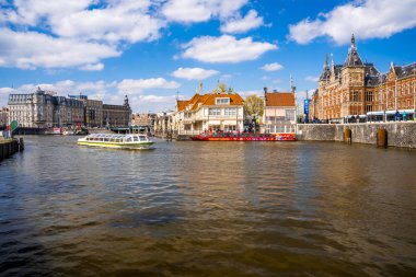 Amsterdam, Hollanda. 10 Mayıs 2019. Dar kanallı Amsterdam şehrinin güzel manzarası, şehrin içinden geçen tekneler ve kanallar boyunca küçük renkli evler..