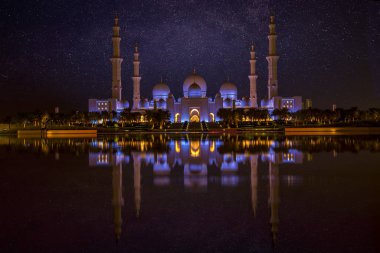 Abu Dabi, Birleşik Arap Emirlikleri 'ndeki Şeyh Zayed Büyük Camii' nin üzerinde yıldızlarla dolu güzel bir gece göğü. Dünyanın en büyük üçüncü camisi.. 