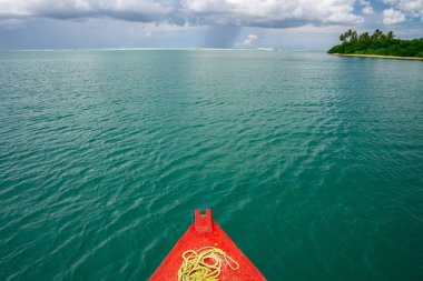 Şeffaf ve berrak turkuaz su kenarındaki uzak bir cennet adasında renkli bir balıkçı teknesi. Yaz havası ruhu. Yerel balıkçı aracı.