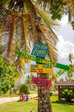 Tobago. 10 Mayıs 2019. Sörf alanı için plaj tabelası. Vintage efekt renk filtresi. Uçurtma sörfü, rüzgar sörfü, palmiyeye yapıştırılmış wakeboard tabelaları..