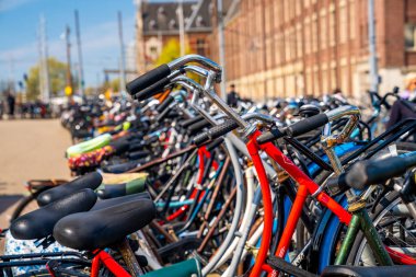 Amsterdam, Hollanda. 30 Nisan 2018. Güneşli baharda tipik Amsterdam caddesi. Amsterdam, Hollanda 'daki köprünün yanında park halindeki bisikletler..