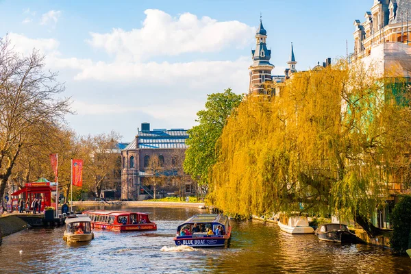 Amsterdam, Hollanda. 10 Mayıs 2019. Amsterdam Kanalı Amstel, Hollanda, Hollanda, Hollanda 'da alacakaranlık mavi saatinde tekneden tipik Hollandalı evler, yüzen ev ve ışıltılı yol..