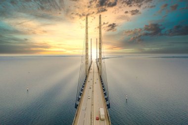 Kopenhag Danimarka ile Malmö İsveç arasındaki Öresund köprüsü gün batımında deniz üzerinde.