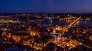 Büyülü pembe günbatımında Riga 'nın eski kasabasının güzel panoramik manzarası. Şehir sokak lambalarıyla aydınlanıyor..
