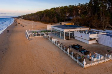 Jurmala, Letonya. 10 Haziran 2019. Sahilde, deniz kenarında bulunan bir plaj restoranı. Güzel dinlenme yeri büyülü günbatımında soğuk bölge.