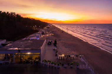 Jurmala, Letonya. 10 Haziran 2019. Sahilde, deniz kenarında bulunan bir plaj restoranı. Güzel dinlenme yeri büyülü günbatımında soğuk bölge.