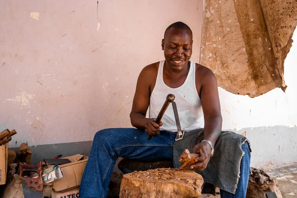 Tanzanya, Kilimanjaro. 20 Mart 2020. Diy kavramı. İnsan hatıra olarak satmak için ahşap bir hayvan figürü yapıyor..