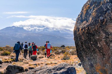 Kilimanjaro, Tanzanya - 15 Mart 2020: Kafalarında eşya taşıyan ve Kilimanjaro Dağı 'na tırmanan Afrikalı hamallar