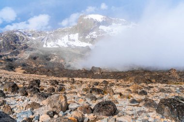 Kilimanjaro dağından Tanzanya ve Kenya 'nın güzel manzarası. Kilimanjaro volkanı etrafındaki kayalar, çalılar ve boş volkanik arazi..