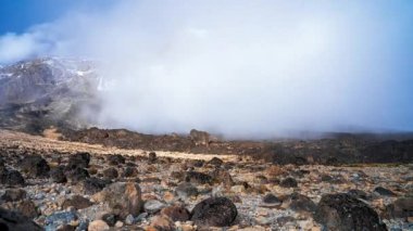 Kilimanjaro Dağı, Kilimanjaro Milli Parkı 'nda Kibo ve Uhuru Tepesi' nin (5895 metre, Afrika 'nın en yüksek dağı) zaman görüşü. Volkanın üzerinde yüzen bulutlarla güzel bir manzara..