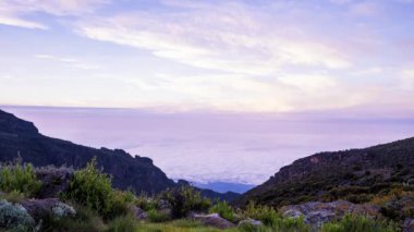 Kilimanjaro Dağı, Kilimanjaro Milli Parkı 'nda Kibo ve Uhuru Tepesi' nin (5895 metre, Afrika 'nın en yüksek dağı) zaman görüşü. Volkanın üzerinde yüzen bulutlarla güzel bir manzara..