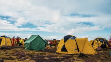 Kilimanjaro Dağı 'nın eteklerinde kamp kuran çadırlar. Çadırların üzerinde hareket eden bulutların güzel zaman çizelgesi. 