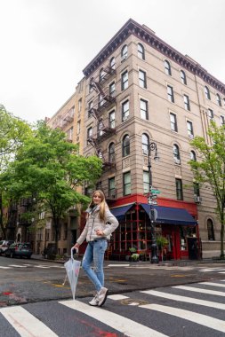 Genç kız, Greenwich Village 'da, Bedford Caddesi' nin köşesinde Grove Caddesi 'nde Friends' in ünlü Amerikan televizyon dizisinde yer alıyor.