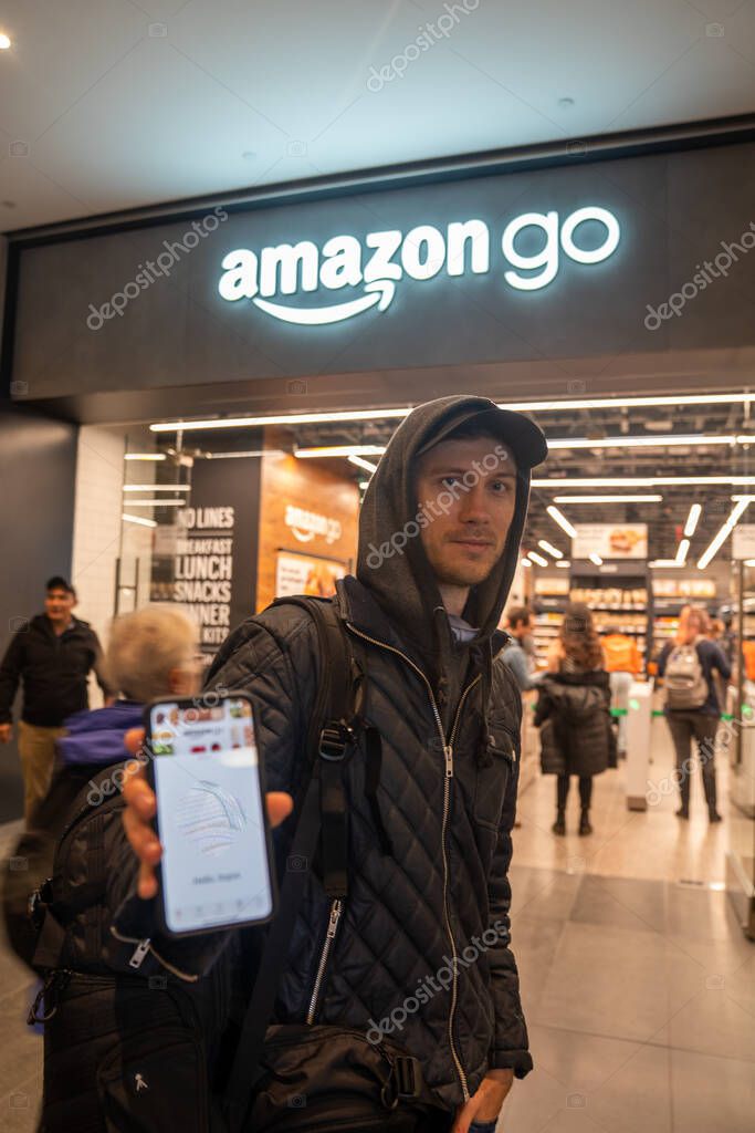 New York, USA. May 10, 2019.  Young man standing near Amazon Go store in New York, ready to enter iwth his phone app.