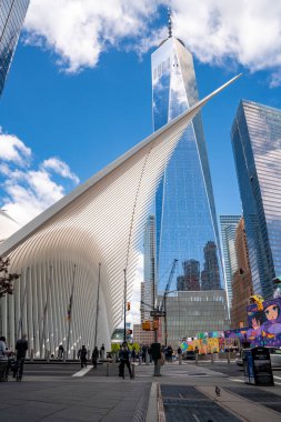 NEW YORK CITY - 10 Mayıs 2019: Oculus ulaşım merkezinin ayırt edici mimari formu One World Trade Center kulesinin parlak manzarasının önünde duruyor.