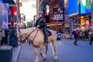 NEW YORK CITY - 9 Mayıs 2019: Gece Times Meydanı 'nda at sırtında bir NYPD polisi, arka planda neon tabelalar. 120mm 'lik bir filmde çekildi..