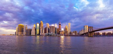 Brooklyn Parkı 'ndan Brooklyn Köprüsü' nün büyülü akşam mor gün batımı manzarası Hudson Nehri 'nin diğer tarafındaki Manhattan manzaralı..