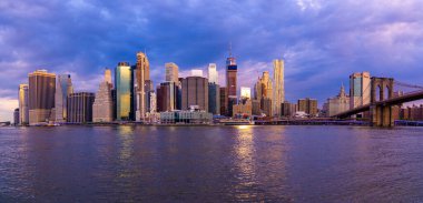Brooklyn Parkı 'ndan Brooklyn Köprüsü' nün büyülü akşam mor gün batımı manzarası Hudson Nehri 'nin diğer tarafındaki Manhattan manzaralı..