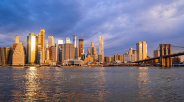 Brooklyn Parkı 'ndan Brooklyn Köprüsü' nün büyülü akşam mor gün batımı manzarası Hudson Nehri 'nin diğer tarafındaki Manhattan manzaralı..